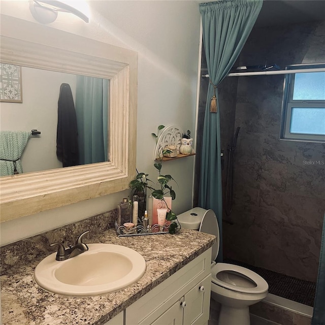 bathroom with vanity, toilet, and a tile shower