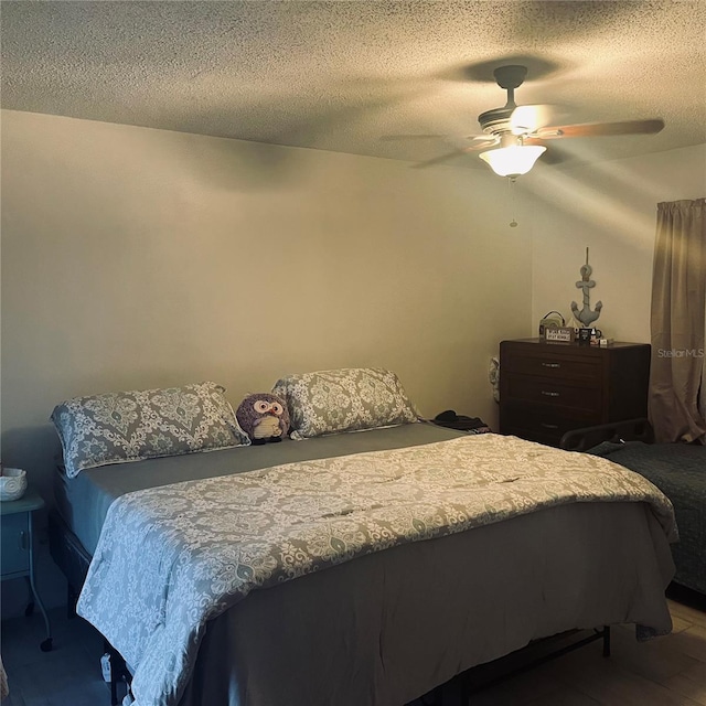 bedroom featuring ceiling fan and a textured ceiling