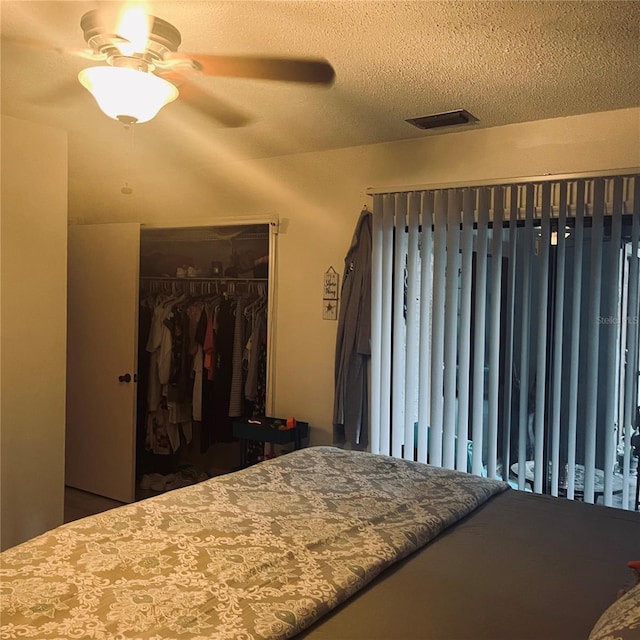 bedroom with ceiling fan, a closet, and a textured ceiling