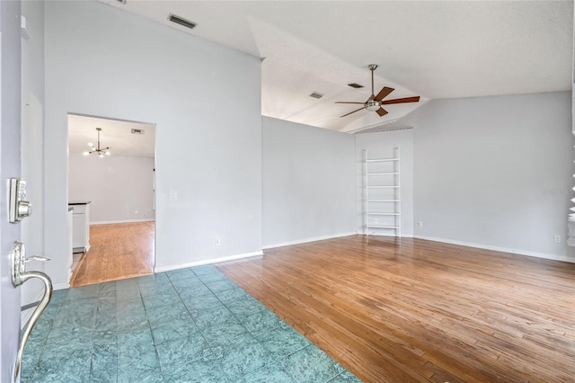 empty room featuring hardwood / wood-style flooring, lofted ceiling, and ceiling fan with notable chandelier