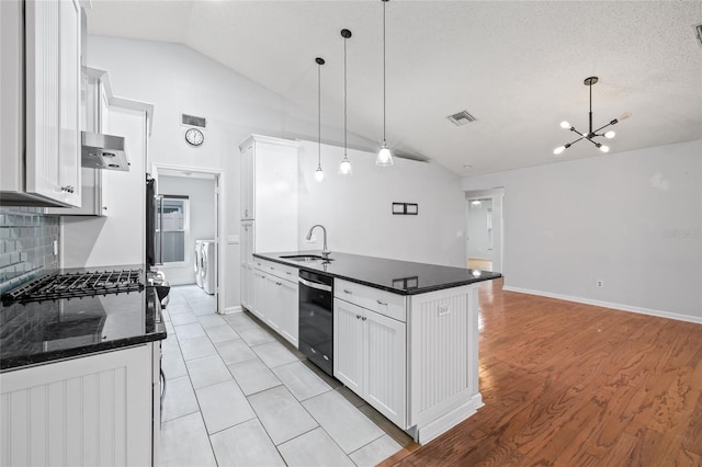 kitchen with vaulted ceiling, ventilation hood, sink, white cabinets, and hanging light fixtures