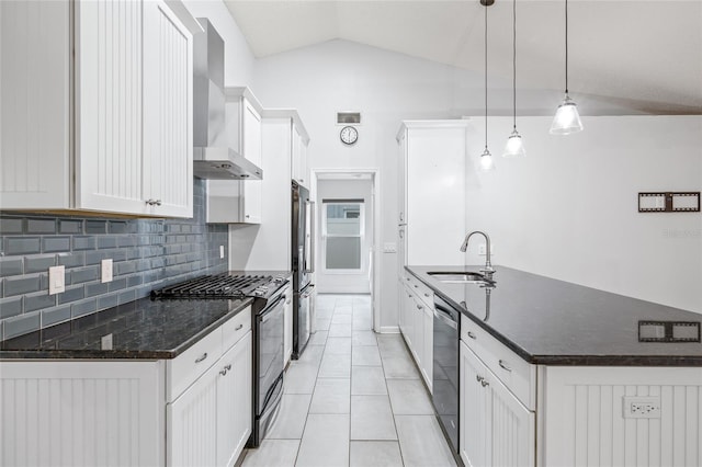 kitchen with sink, decorative light fixtures, white cabinets, stainless steel appliances, and wall chimney range hood