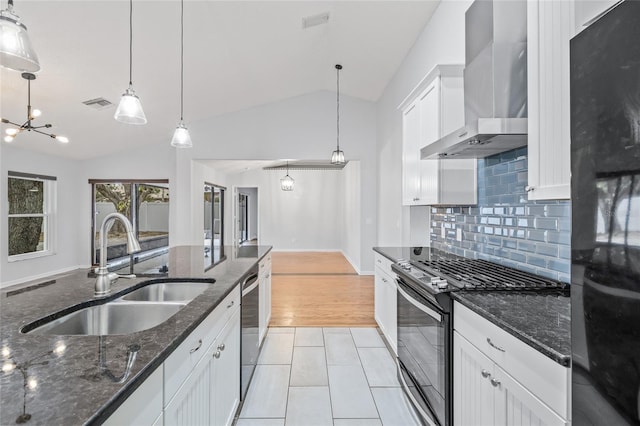 kitchen with gas stove, sink, wall chimney range hood, and white cabinets