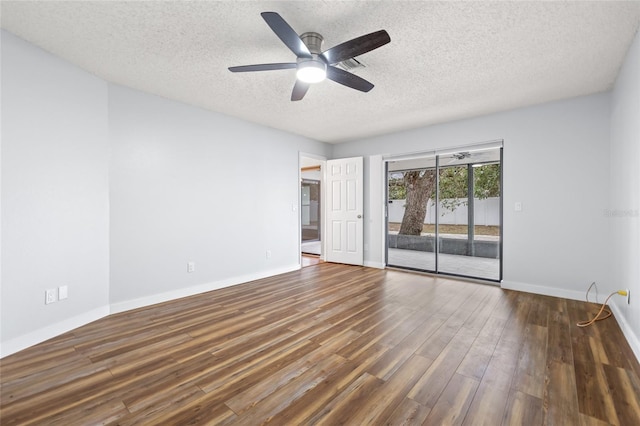 empty room with ceiling fan, dark wood-type flooring, and a textured ceiling