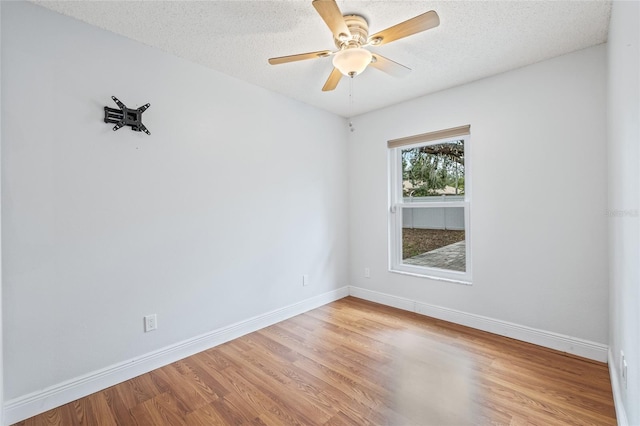 unfurnished room with hardwood / wood-style flooring, ceiling fan, and a textured ceiling