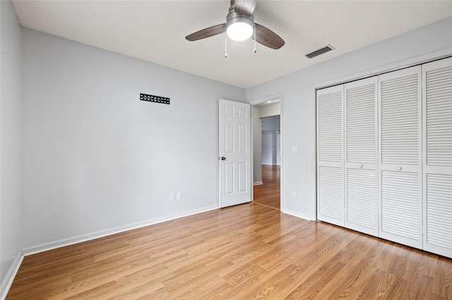 unfurnished bedroom with light hardwood / wood-style flooring, a closet, and ceiling fan