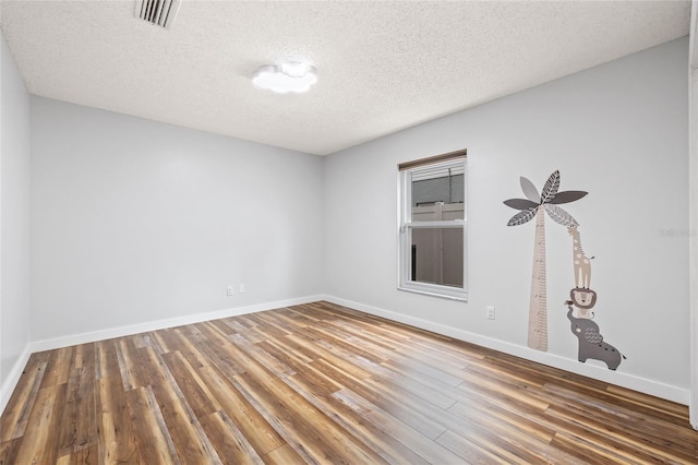 spare room with wood-type flooring and a textured ceiling