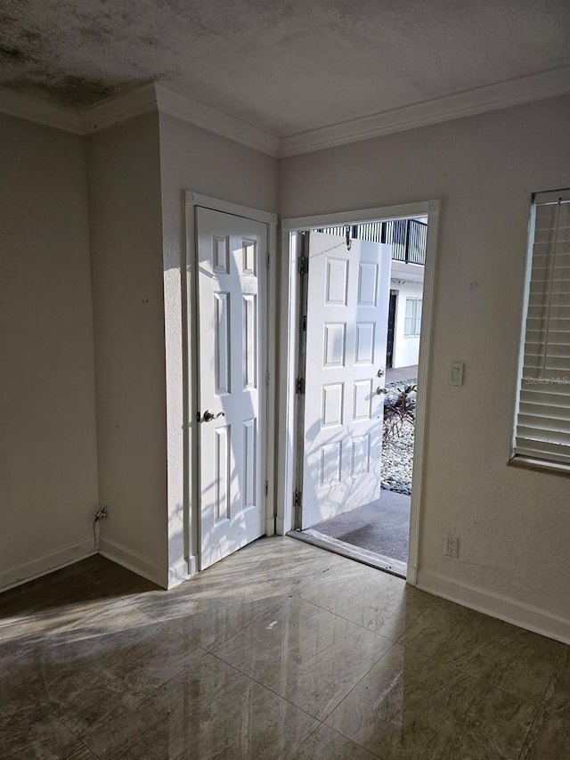 doorway to outside featuring ornamental molding and a textured ceiling