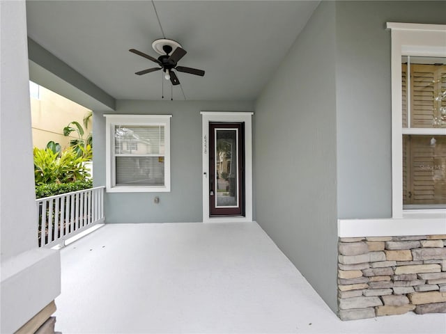 entrance to property with a porch and ceiling fan