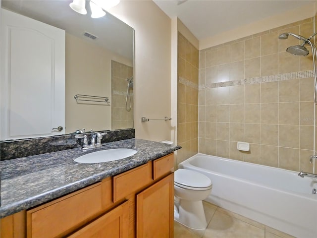 full bathroom featuring vanity, tiled shower / bath, tile patterned floors, and toilet