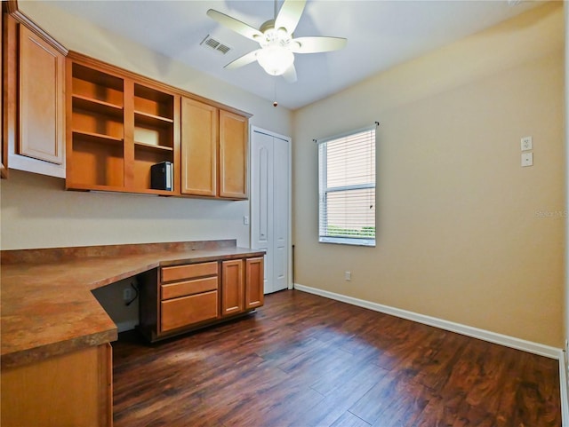 kitchen with built in desk, dark hardwood / wood-style floors, and ceiling fan