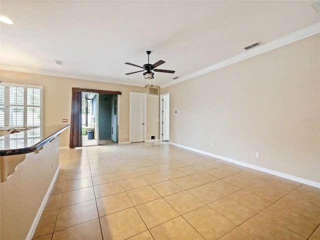 empty room featuring ornamental molding, ceiling fan, and light tile patterned flooring