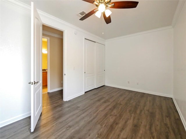 unfurnished bedroom featuring dark wood-type flooring, ornamental molding, a closet, and ceiling fan