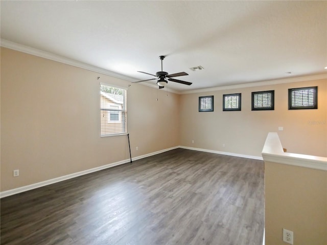 spare room with crown molding, ceiling fan, and dark wood-type flooring