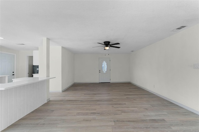 entryway with ceiling fan, a textured ceiling, and light hardwood / wood-style floors