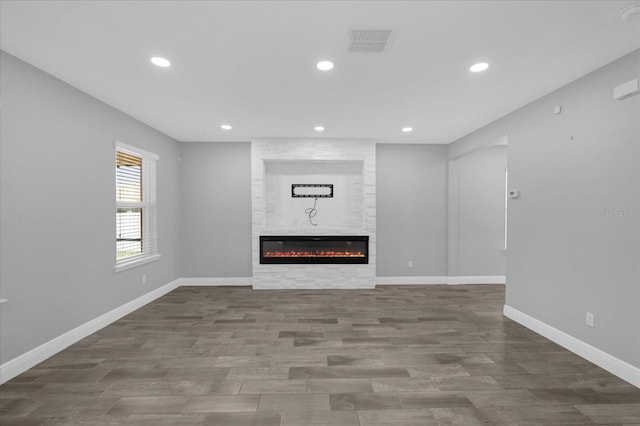 unfurnished living room with hardwood / wood-style flooring and a fireplace