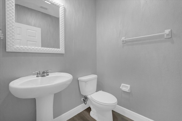 bathroom with wood-type flooring, sink, and toilet