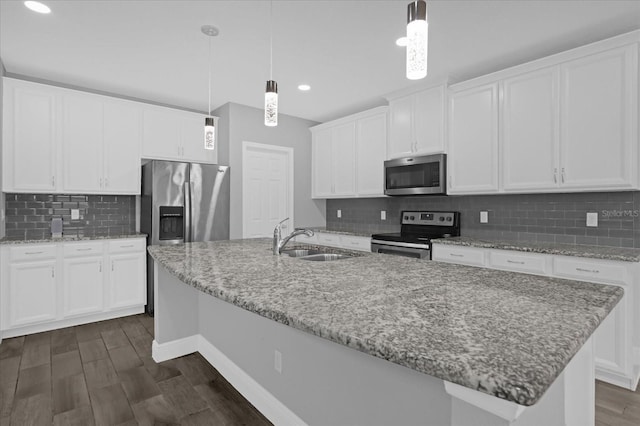 kitchen with white cabinetry, appliances with stainless steel finishes, sink, and hanging light fixtures