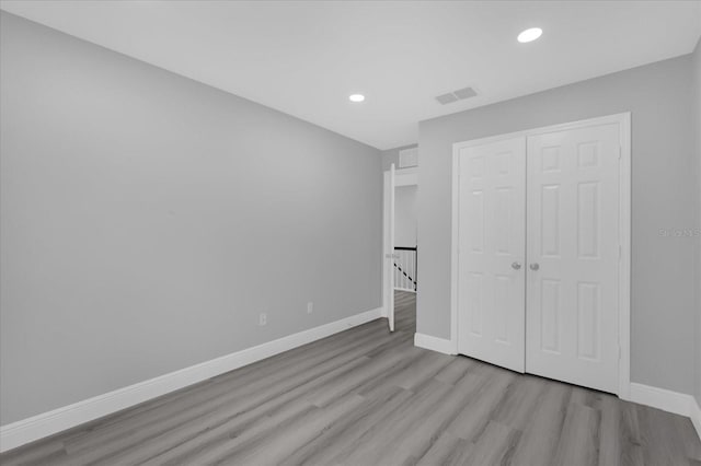 unfurnished bedroom with a closet and light wood-type flooring