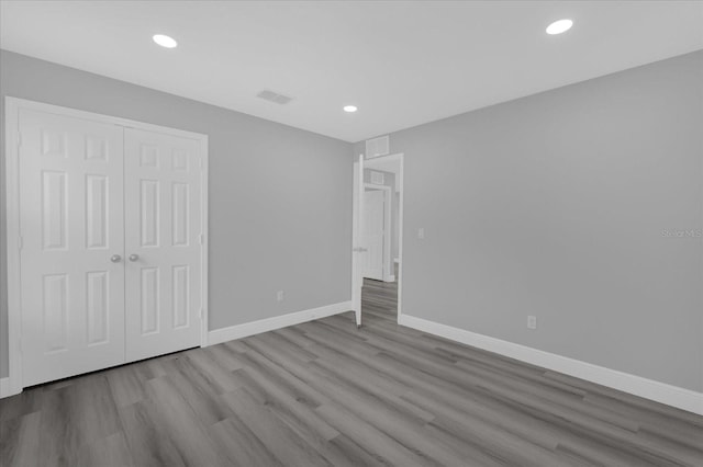 unfurnished bedroom featuring a closet and light hardwood / wood-style flooring