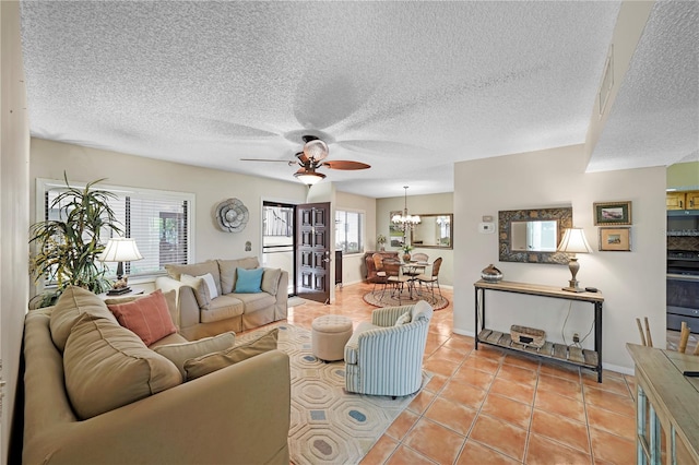 tiled living room featuring ceiling fan with notable chandelier and a textured ceiling