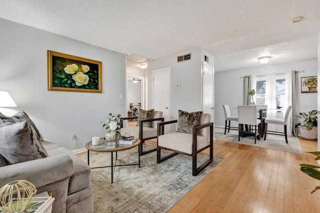 living room with light hardwood / wood-style flooring and a textured ceiling