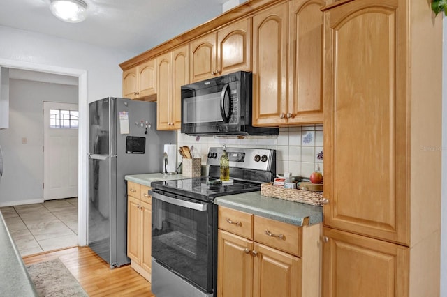 kitchen with tasteful backsplash, stainless steel appliances, and light wood-type flooring