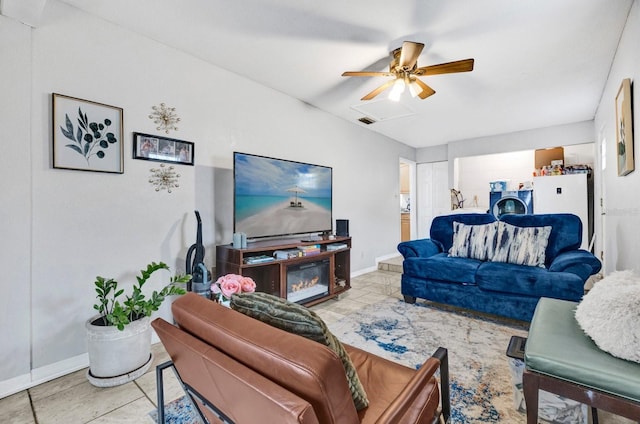 living room featuring ceiling fan and washer / dryer