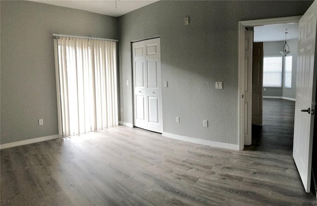 unfurnished bedroom featuring hardwood / wood-style floors and a closet