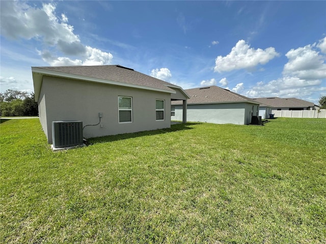 back of house with a yard and central air condition unit