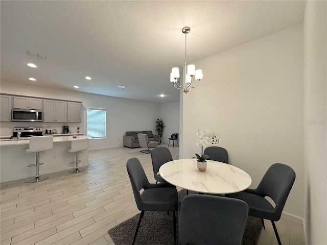 dining room with a notable chandelier and light wood-type flooring