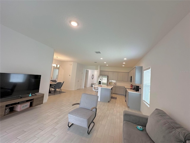 living room featuring light hardwood / wood-style floors and a notable chandelier