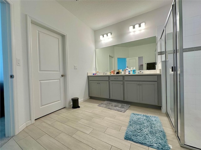 bathroom featuring vanity, a textured ceiling, and walk in shower