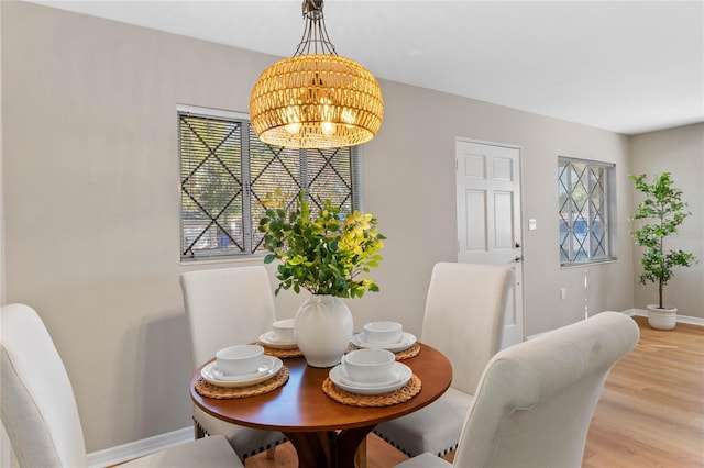 dining space with light wood-type flooring and a notable chandelier