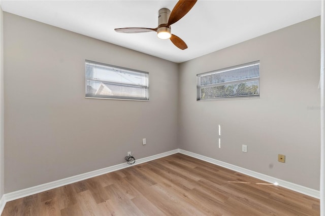 empty room featuring plenty of natural light, ceiling fan, and light hardwood / wood-style flooring