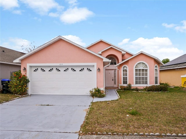 view of front of property featuring a garage and a front lawn