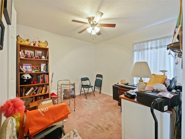 carpeted office space featuring ceiling fan and a textured ceiling