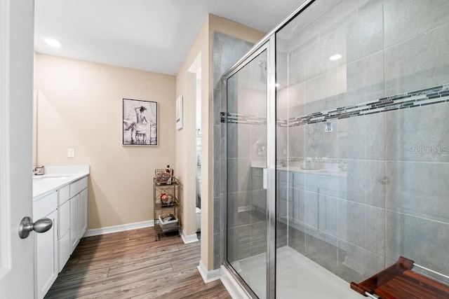 bathroom featuring walk in shower, wood-type flooring, and vanity