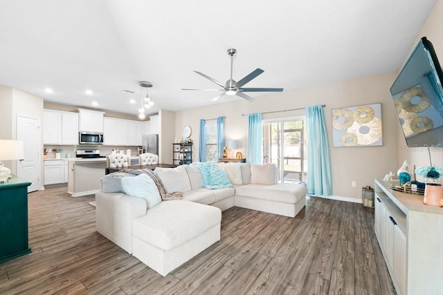 living room with ceiling fan and light wood-type flooring