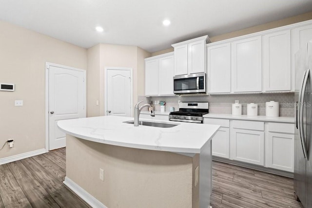 kitchen featuring white cabinetry, appliances with stainless steel finishes, a kitchen island with sink, and sink