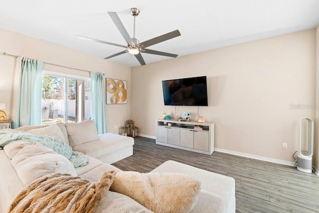 living room with ceiling fan and dark hardwood / wood-style flooring