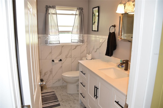 423 Longfellow Blvd, Lakeland, FL 33801 - bathroom featuring tile walls, toilet, vanity, and a wainscoted wall