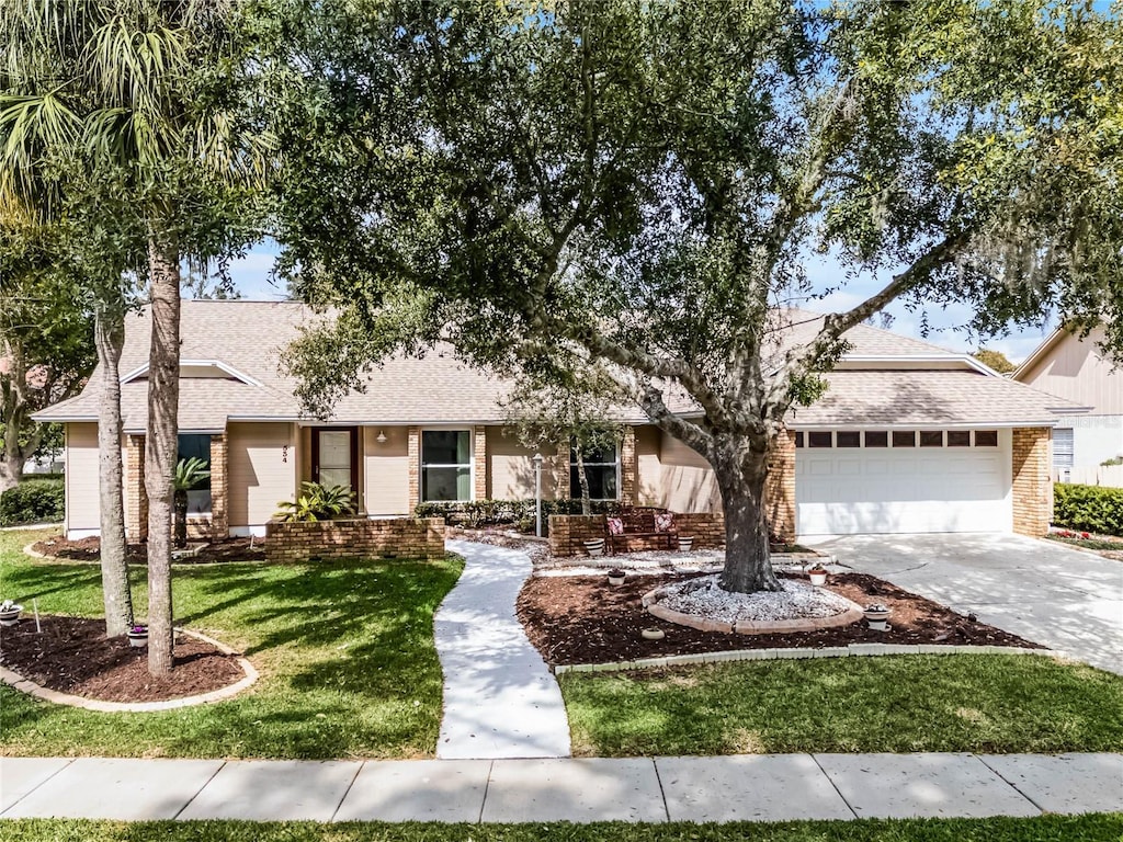 single story home featuring a garage and a front yard