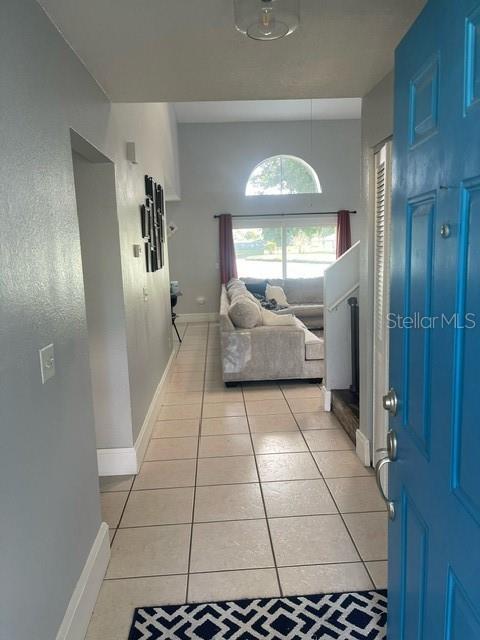 interior space featuring light tile patterned flooring and baseboards