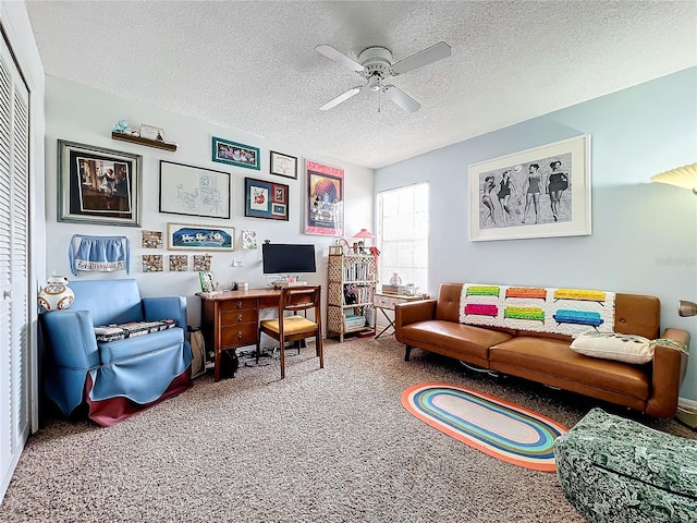 carpeted home office featuring a textured ceiling and ceiling fan