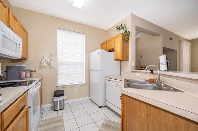 kitchen featuring sink, white appliances, and light tile patterned flooring