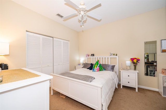 carpeted bedroom with ceiling fan and a closet