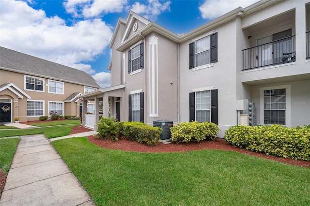 townhome / multi-family property featuring central AC unit and a front yard