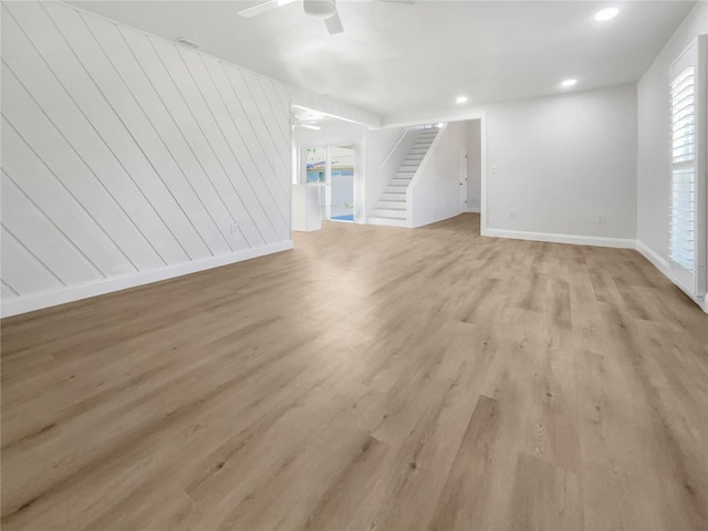 unfurnished living room with ceiling fan and light hardwood / wood-style floors