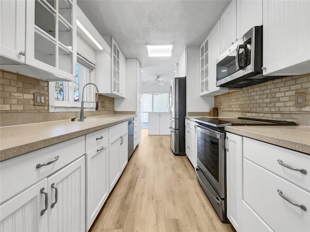 kitchen featuring white cabinetry, sink, stainless steel appliances, and ceiling fan